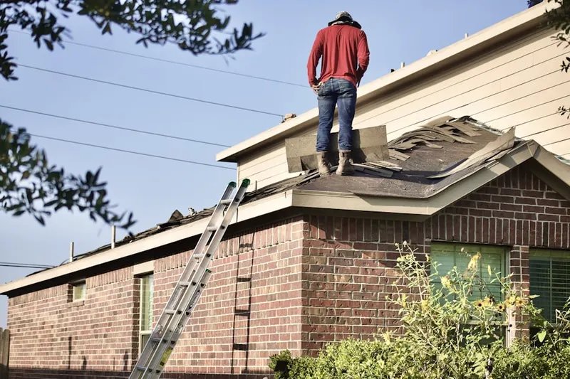 Professional roofer working on a residential roof in Whitfield Estates